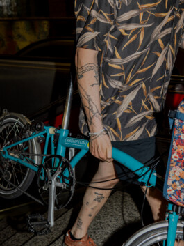 Close-up of a turquoise Brompton bike and patterned shirt 