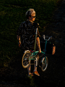 Man walking with folded Brompton bicycle – urban mobility concept 