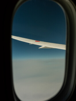 Airplane wing over clouds during flight from Japan 